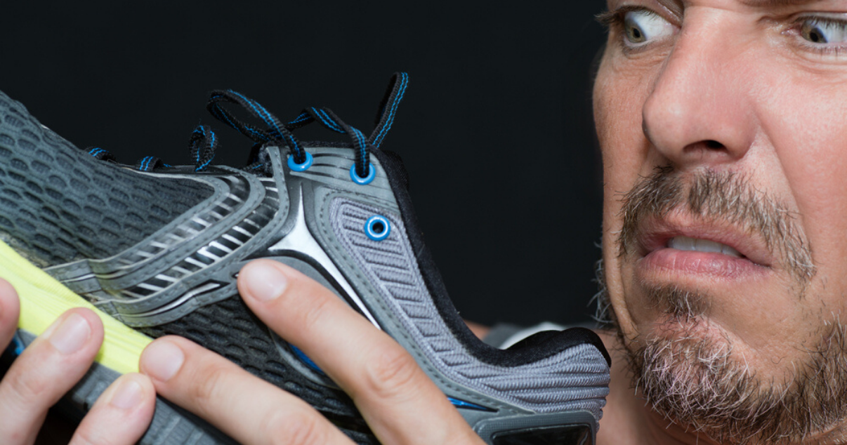 Man disgusted by his sweaty feet and smelly shoes wondering how to keep his feet dry