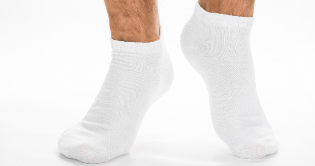 man changing into a fresh pair of cotton socks to prevent athletes foot