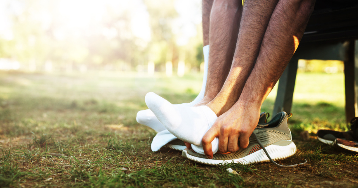 Man changing into new socks getting ready to go for a run while remembering the tips for preventing atheles foot infection