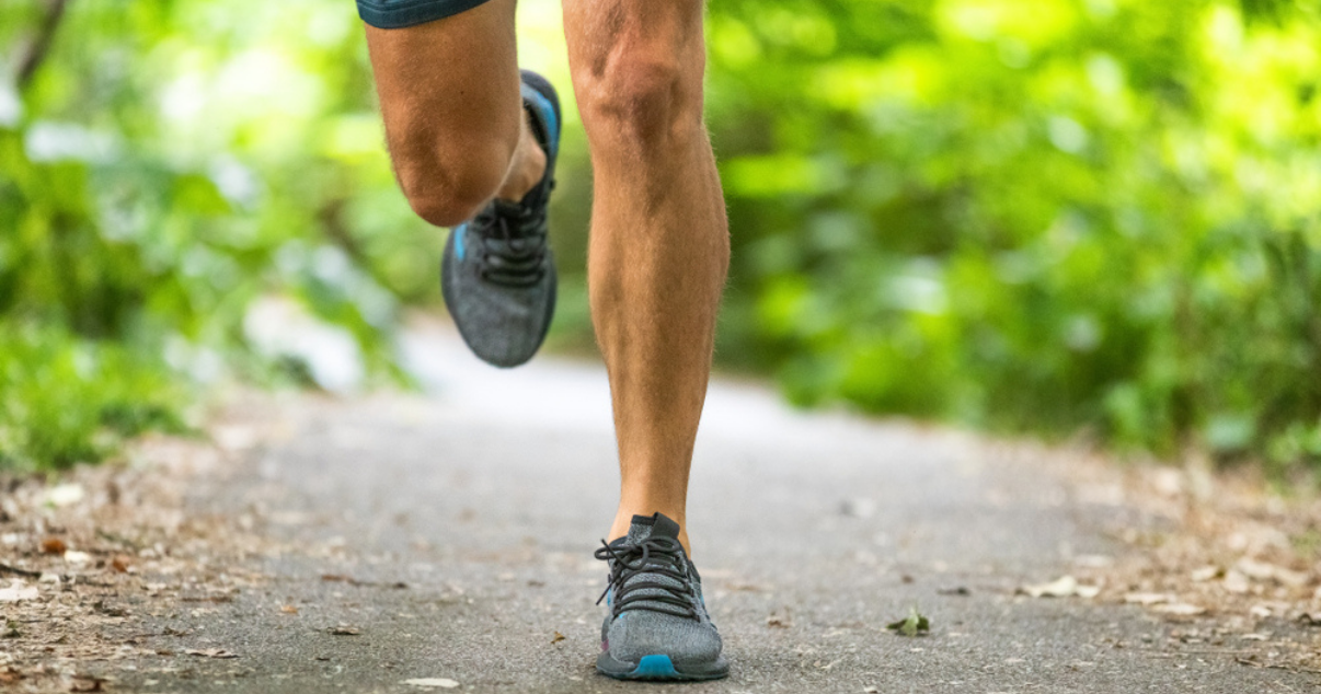 Man running outdoors in the park in spring with running shoes wondering about athletes foot prevention