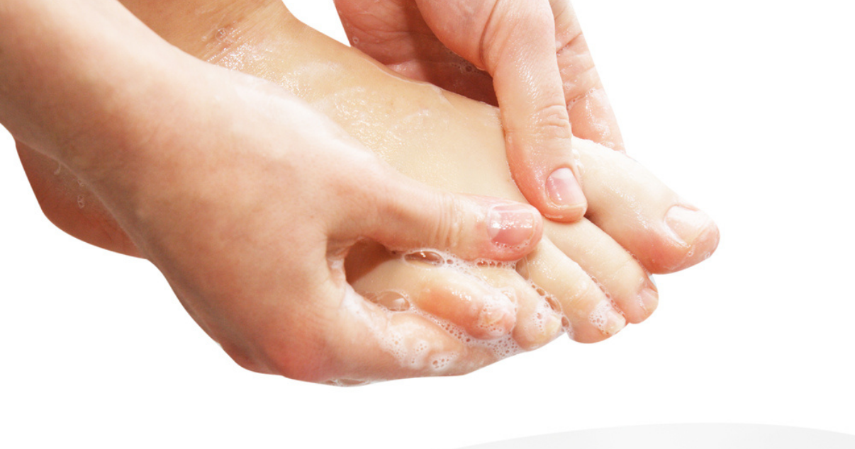 Woman washing her feet as she remembers the tips for preventing athletes foot infection