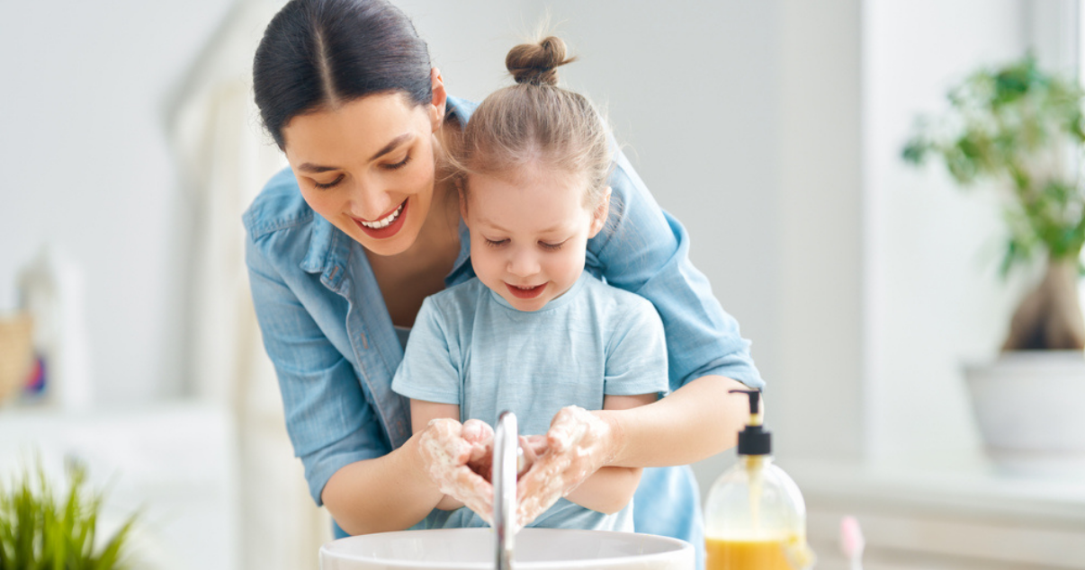 Mom teaching her daughter how to wash her hands for preventing a ringworm infection