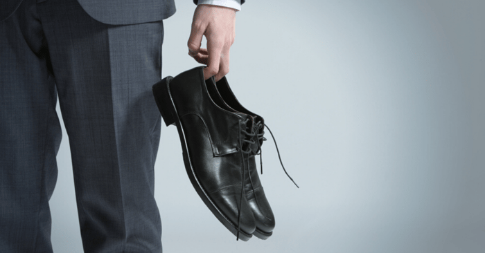 man taking off tight fitting shoes to prevent athletes foot